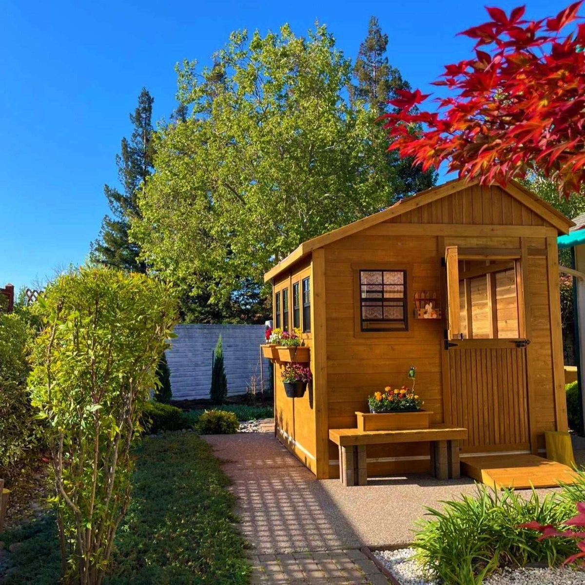 8x12 cedar shed with warm wood siding, Dutch door, windows, flower boxes, and a front bench