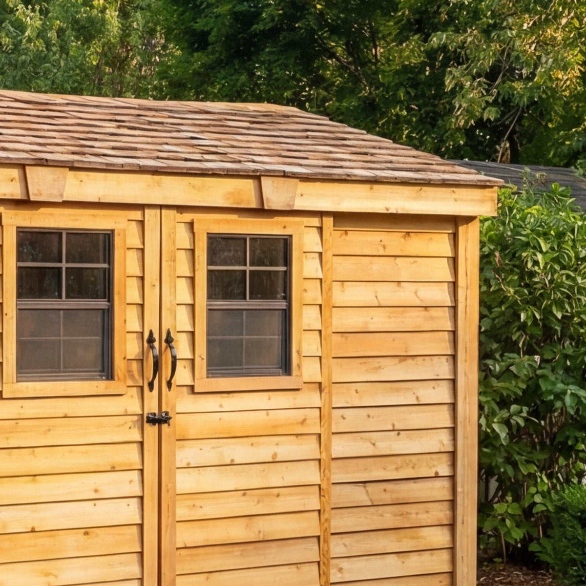 Outdoor Storage cedar shed with natural wood siding, shingle roof, windows, and double doors with black hardware
