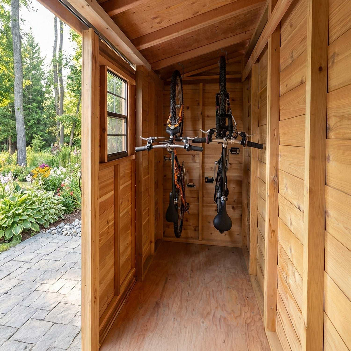 Outdoor Storage cedar shed interior with warm wood walls, window, and bicycles hanging from wall-mounted racks
