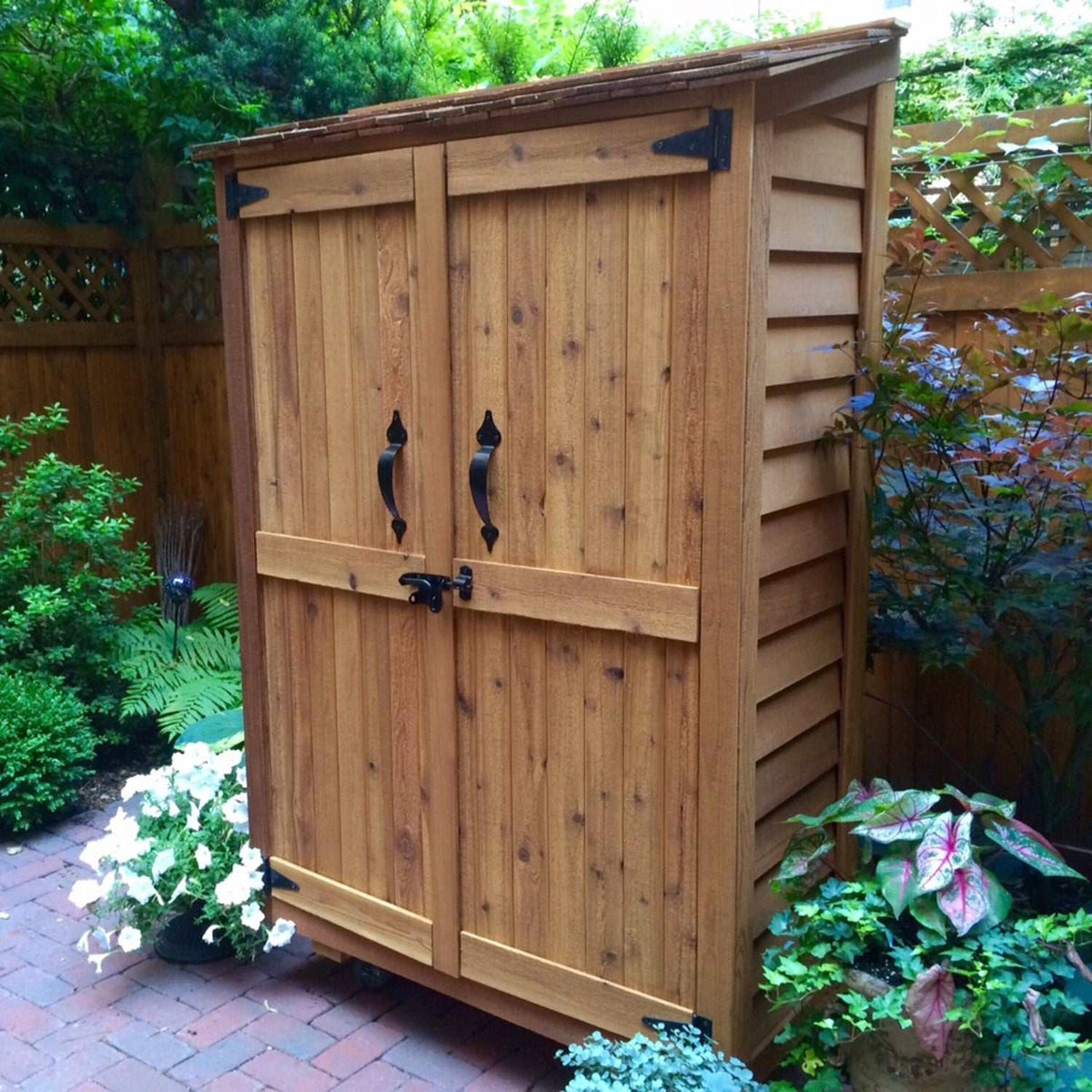 Western Red Cedar Garden Chalet featuring natural wood finish, double doors with black handles, and sloped roof in a garden setting