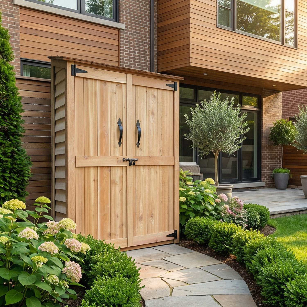 Western Red Cedar Garden Chalet with natural wood finish, double doors, black metal handles, and sloped roof in a landscaped garden setting